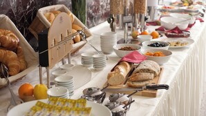 A buffet setup with various food items and utensils. - Hotel Unique Majestic Hauptbahnhof (Dortmund)
