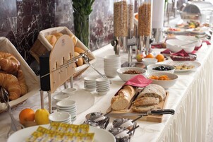 Una mesa de buffet con diversos alimentos y utensilios.