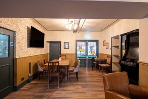 Een restaurant met houten vloeren, een aan de muur bevestigde televisie en een jukebox.