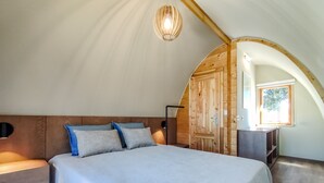 Ein Schlafzimmer mit einem großen Bett, einem Holzkopfteil und einem Schrank aus Holz.
