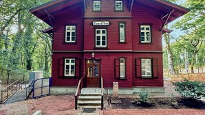A two-story red building with a sign reading "Haus Eim" at the entrance.