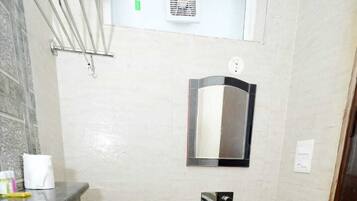 A bathroom with a white toilet, a sink, and a mirror on the wall.
