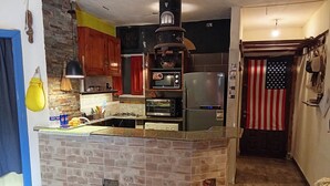 A kitchen with a central island, a microwave, a refrigerator, and a stove.