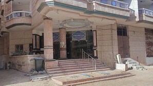 A building with a central entrance, columns, and a staircase leading up to the entrance.