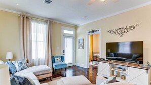 A living room with a sofa set, a television, and a decorative wall piece. - Walk to Beach! Family-friendly Galveston Home (Galveston)