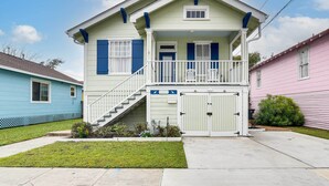 A two-story house with a front porch, a staircase, and a garage. - Walk to Beach! Family-friendly Galveston Home (Galveston)