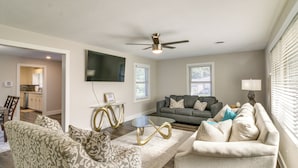 A living room with a sofa, chairs, a coffee table, and a ceiling fan. - Home w/ Patio & Games Near Dtwn Pensacola! (Pensacola)