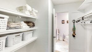 A laundry room with shelves holding folded towels and laundry baskets. - Waterfront Condo w/ Dock Access in Carlsbad! (Carlsbad)