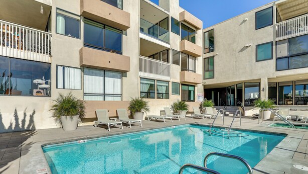 A modern hotel with a swimming pool, multiple balconies, and outdoor seating areas. - Waterfront Condo w/ Dock Access in Carlsbad! (Carlsbad)