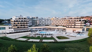 Un hotel moderno con un patio central, varios pisos y una piscina.