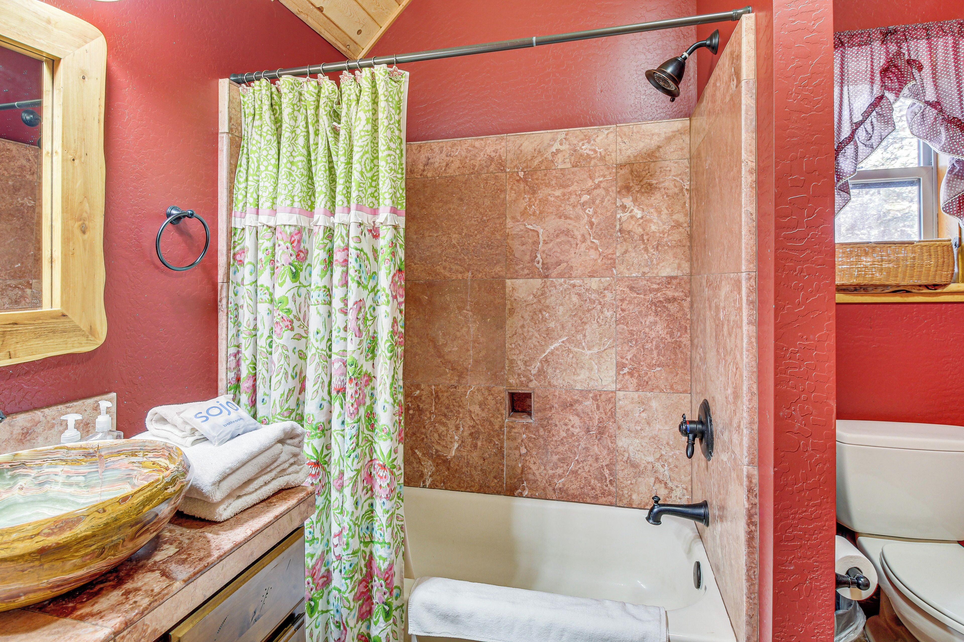 A bathroom with a bathtub, a shower, a sink with a bowl, and a toilet.