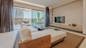 A modern hotel room with a large bed, a TV mounted on the wall, and a balcony with outdoor furniture. - Silence Villas (Fethiye)