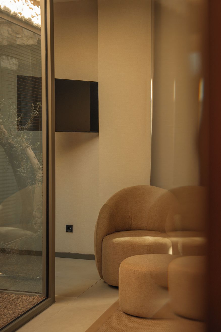A modern living room with a sofa and a television mounted on the wall.