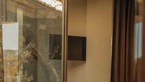 A modern living room with a glass partition, a mounted TV, and a comfortable seating area. - Silence Villas (Fethiye)