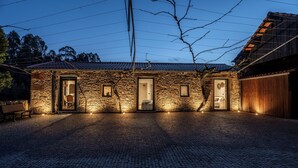 A stone building with a cobblestone courtyard, wooden doors, and a bench. - Garden retreat near Porto (Porto)