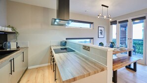A modern kitchen with a wooden countertop, built-in appliances, and a large window. - Host Stay Ropewalks Quarters VI (Liverpool)