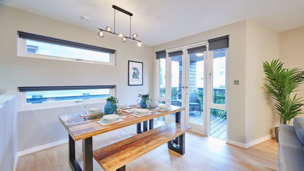 A modern kitchen with a wooden table, bench, and pendant lighting. - Host Stay Ropewalks Quarters VI (Liverpool)