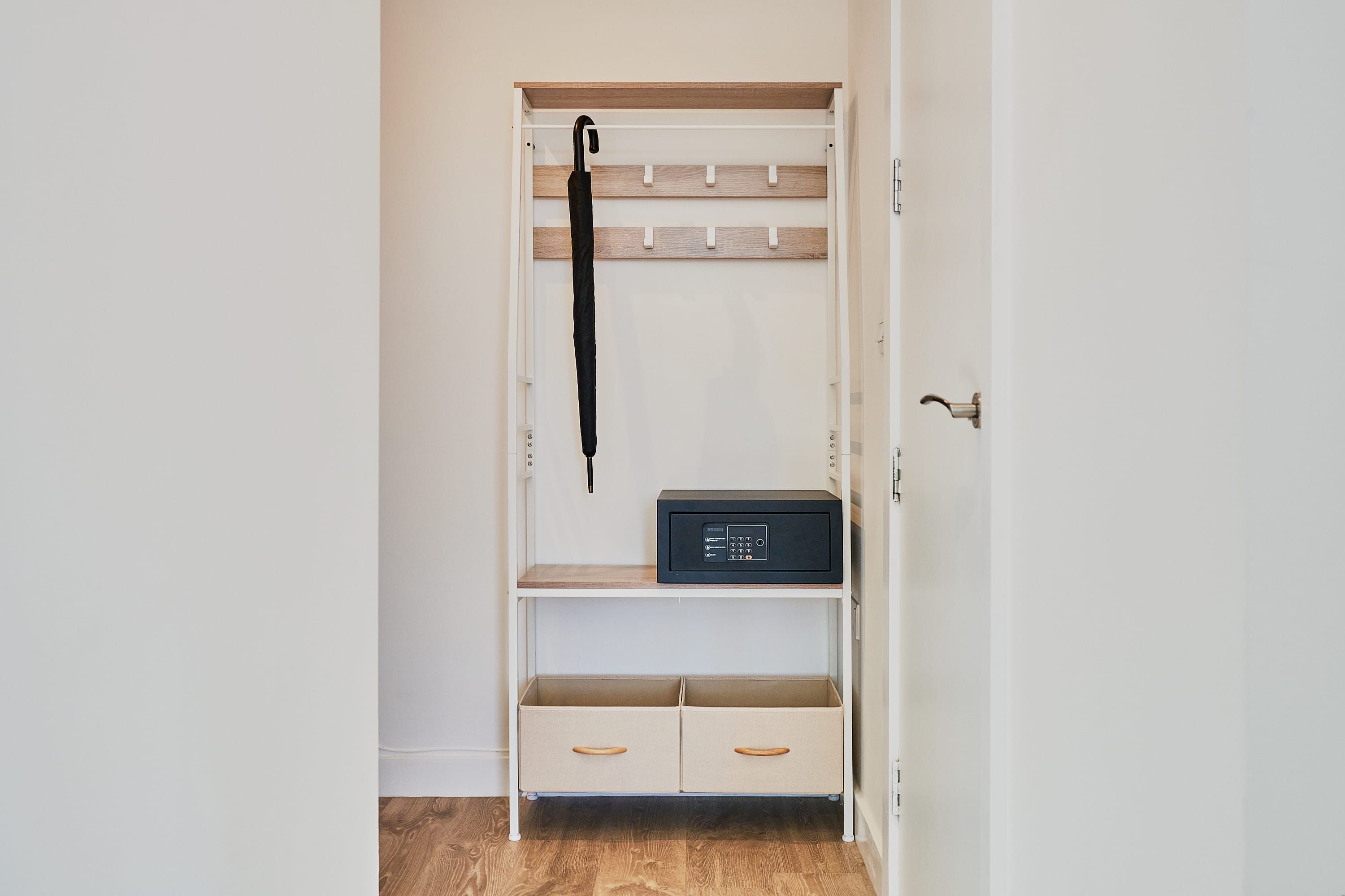 A closet with a hanging rack, a radio, and two storage drawers.