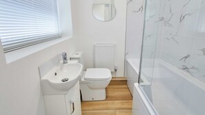 Ein modernes Badezimmer mit Waschbecken, Toilette und Badewanne.