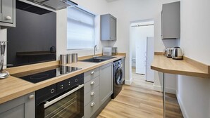 Eine moderne Küche mit Einbauofen, Mikrowelle und Waschmaschine.