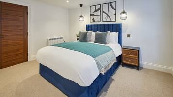 A bedroom with a bed, a nightstand, a wooden door, and a radiator.