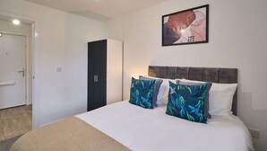 A bedroom with a bed, a wardrobe, and a framed picture on the wall. - Host Stay 23 Waterside Place (Taunton)