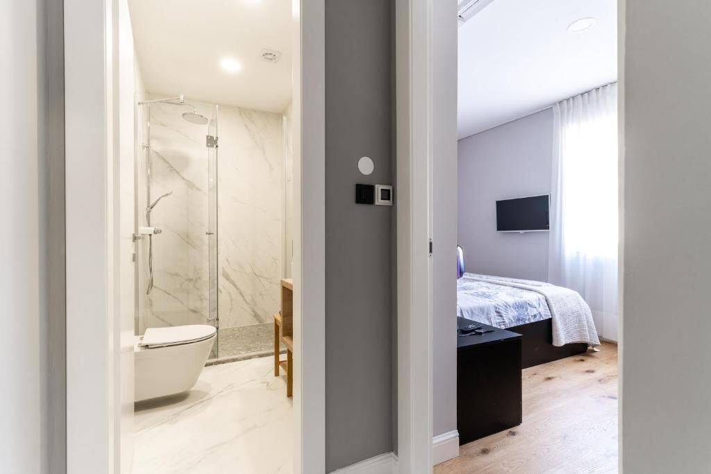 Un bagno moderno con doccia, servizi igienici e pareti in marmo.