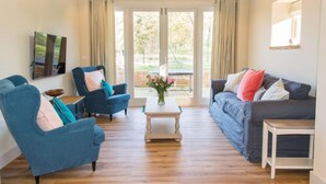 A living room with two sofas, a coffee table, and a TV. - Host Stay Boathouse Barn (Norwich)