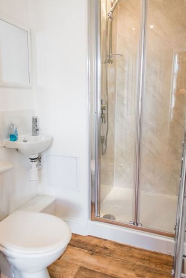Ein Badezimmer mit Toilette, Waschbecken und einer Duschkabine.