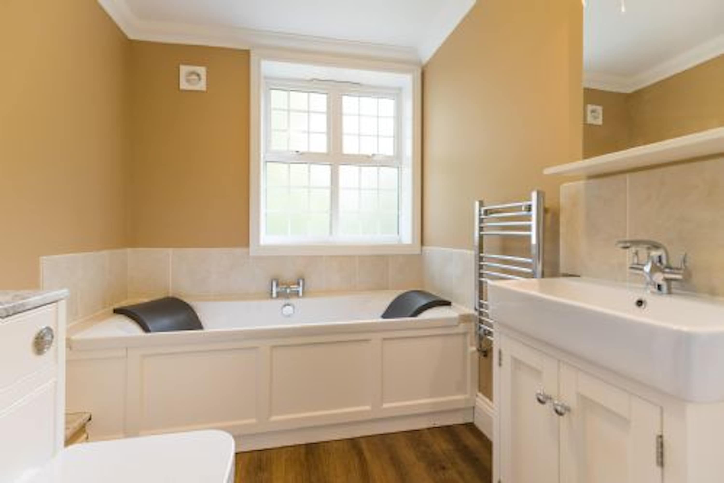 A bathroom with a bathtub, a sink, and a window.
