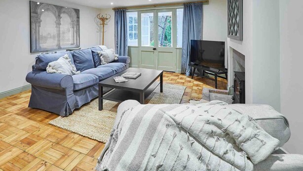 Ein Wohnzimmer mit einer Couch, einem Couchtisch, einem Fernseher und einem Kamin.