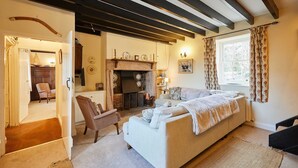 Una sala acogedora con un sofá, una chimenea y una ventana con cortinas.