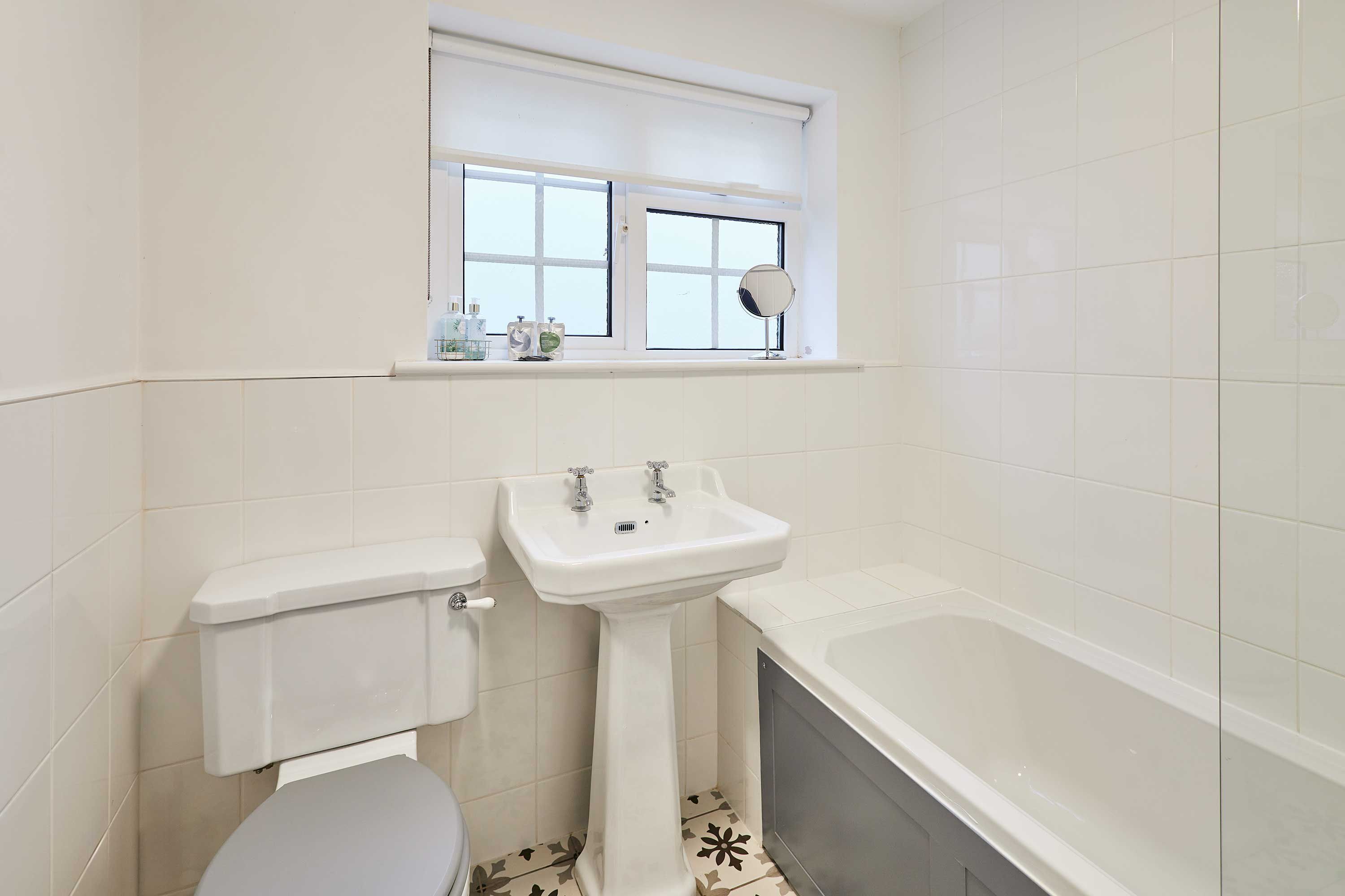 Een badkamer met toilet, wastafel en bad.