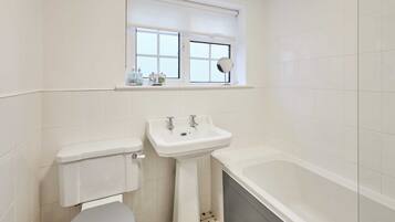 A bathroom with a toilet, sink, and bathtub.