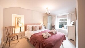 A bedroom with a bed, a chair, a lamp, a chandelier, and a window. - Host Stay White House (Matlock)