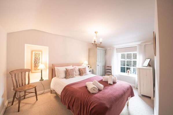 A bedroom with a bed, a chair, a lamp, a chandelier, and a window. - Host Stay White House (Matlock)