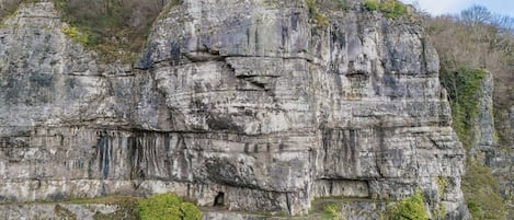 A large rock formation with a narrow path leading up to it.