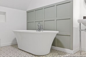 A modern bathroom with a freestanding bathtub, a glass shower enclosure, and a white sink. - Host Stay The Staffordshire Knot (Buxton)