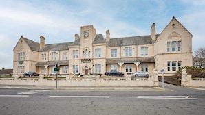 A large, historic building with multiple windows and a prominent clock tower. - Host Stay The Coach House Apartment 2 (Saltburn-by-the-Sea)