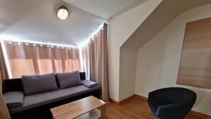 A modern living room with a sofa, a wooden coffee table, and a chair. - Apartment in Bad Kleinkirchheim Near Hiking (Bad Kleinkirchheim)