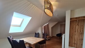 A modern loft apartment with a dining area, a kitchen, and a large window. - Apartment in Bad Kleinkirchheim Near Hiking (Bad Kleinkirchheim)