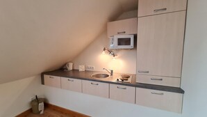 A small kitchenette with a microwave, sink, and cabinets. - Apartment in Bad Kleinkirchheim Near Hiking (Bad Kleinkirchheim)