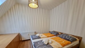 A bedroom with a bed, a radiator, and a wooden bench. - Apartment in Bad Kleinkirchheim Near Hiking (Bad Kleinkirchheim)