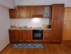 Appartement | Privékeuken | Een koelkast, een oven, een waterkoker, kookgerei, borden en bestek