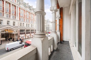 A balcony with classical columns, overlooking a busy street with buildings and vehicles. - Central 1 Bedroom Apartment on Strand opposite Savoy Hotel (Greater London)