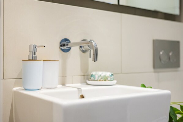 A bathroom with a white sink, a chrome faucet, and two rolls of toilet paper. - Central 1 Bedroom Apartment on Strand opposite Savoy Hotel (Greater London)