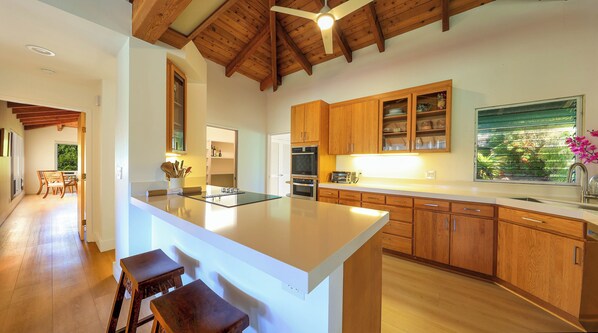 Una cocina moderna con armarios de madera, una isla central y un ventanal grande.