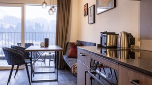 Een moderne keuken met een eethoek, een bank en uitzicht op de omgeving.