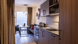 Een moderne keuken met houten kastjes, een roestvrijstalen spoelbak en een eethoek met een tafel en stoelen.