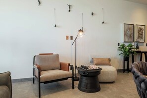 Una sala moderna con sofá, sillón y mesa de centro.
